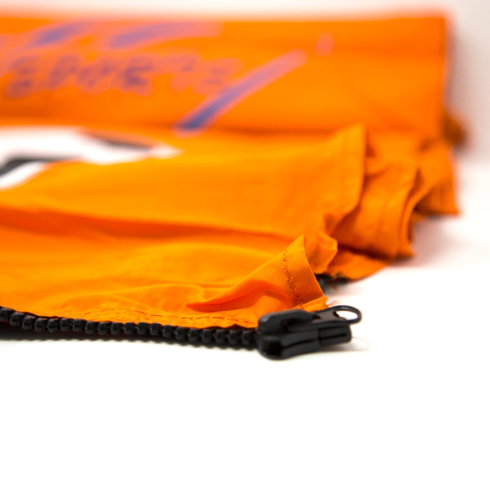 Orange soccer banner has a black zipper on the end of it. 